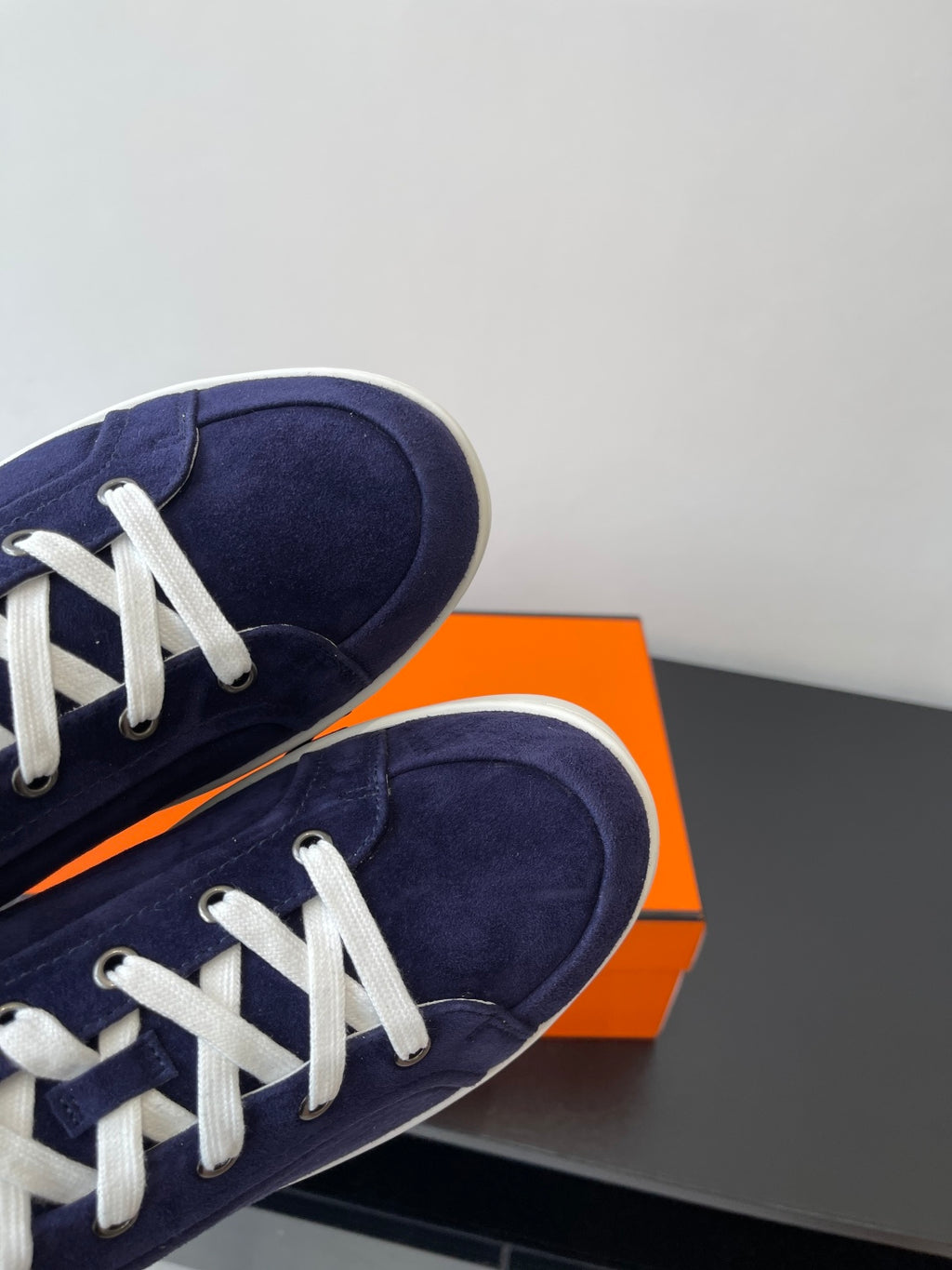 Hermes women's navy suede sneakers close-up of toe and white lace-up