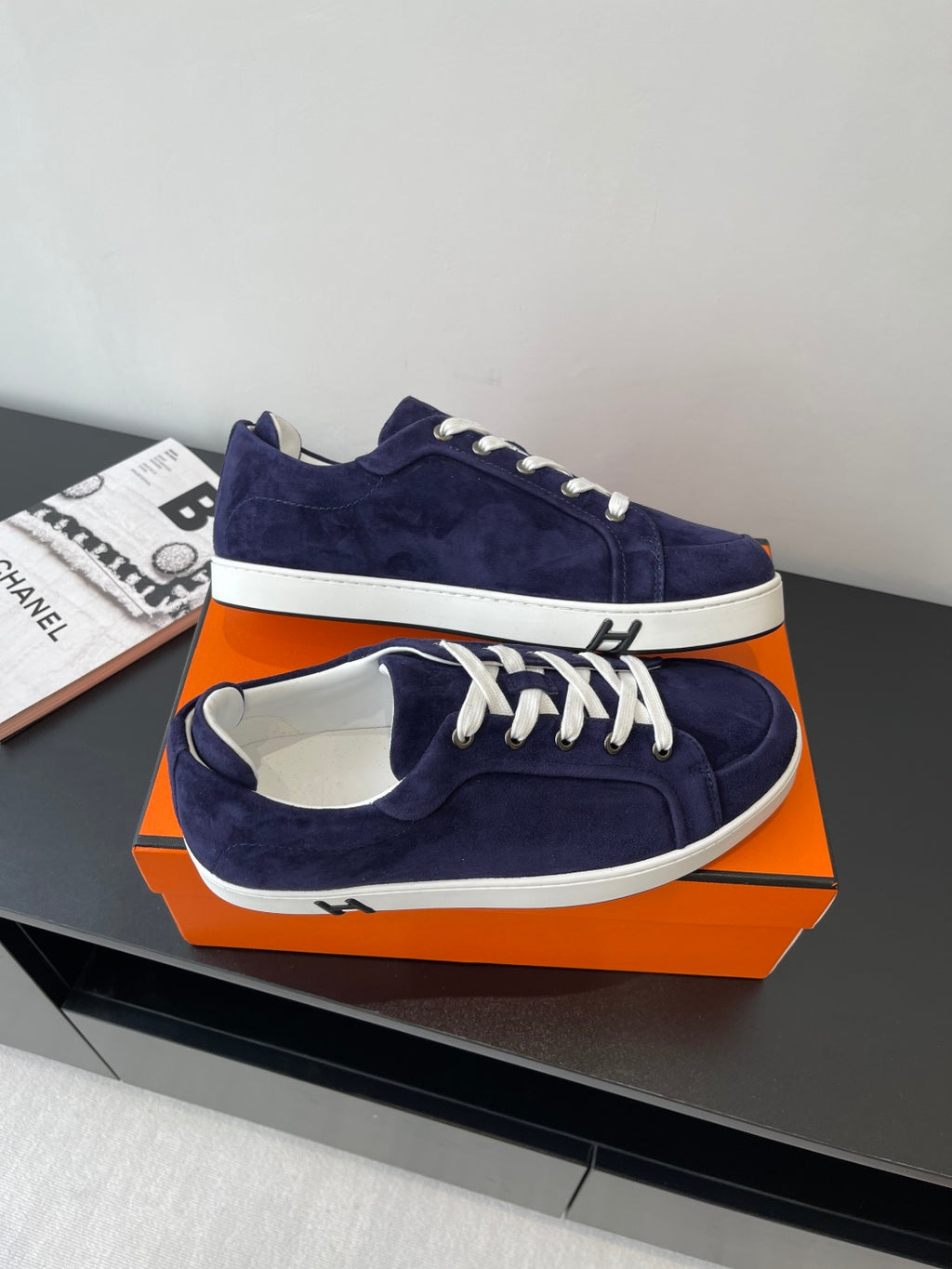 Hermes women's navy suede sneakers with white laces and white trim, angled top view