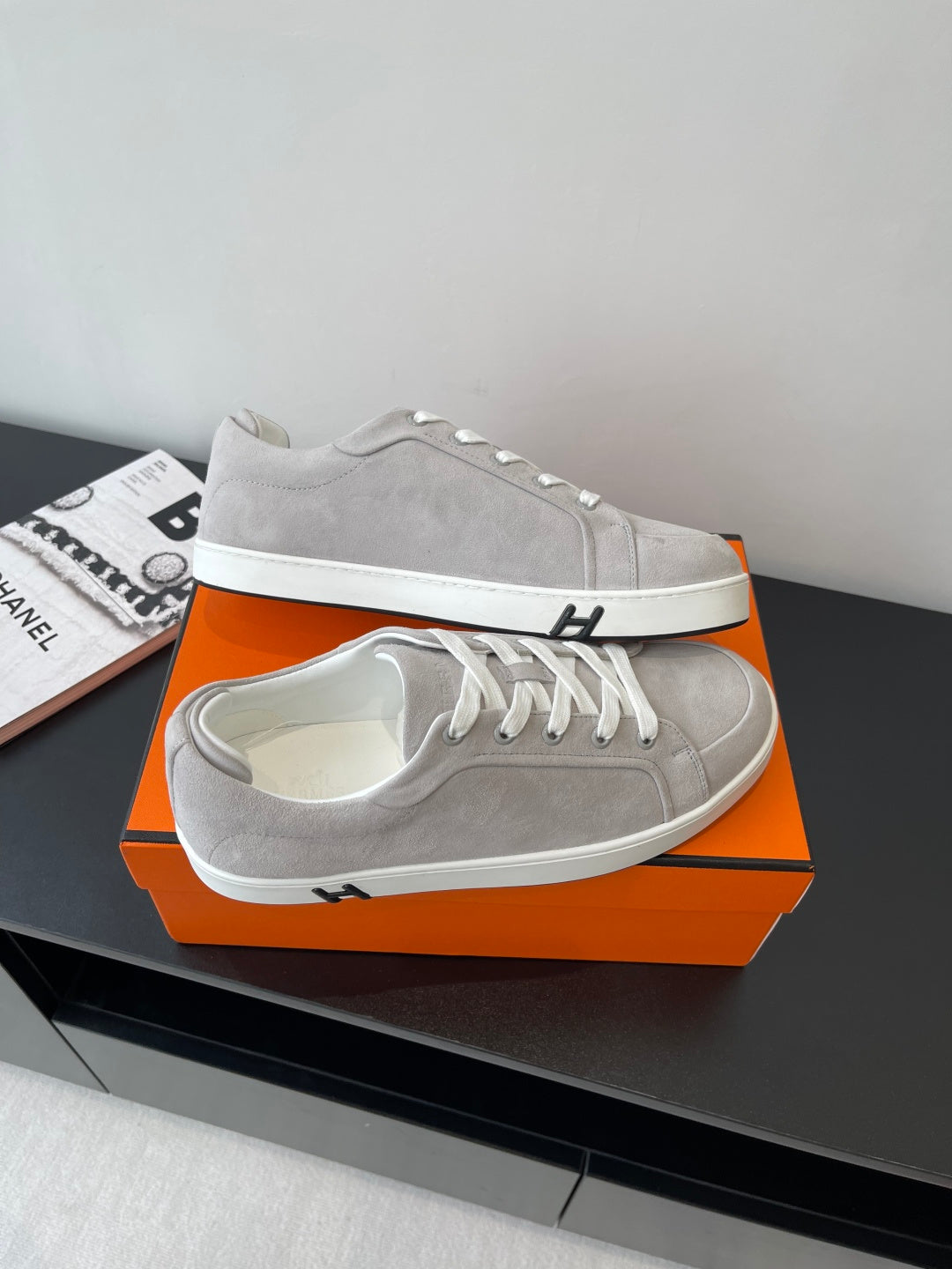 Hermes ladies sneakers on orange box, light gray with white laces and white sole