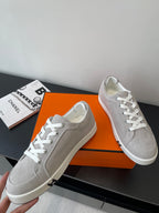Hermes ladies sneakers, light gray with white laces on an orange box