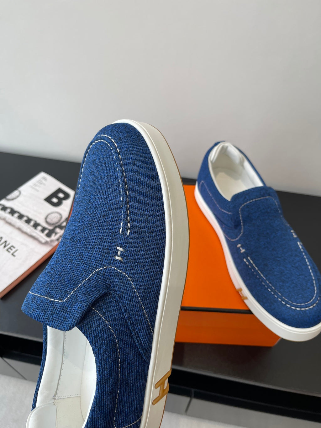 Blue denim slip-on loafers with stitched detail across the side panels.