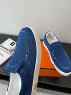 Blue denim slip-on loafers with stitched detail across the side panels.