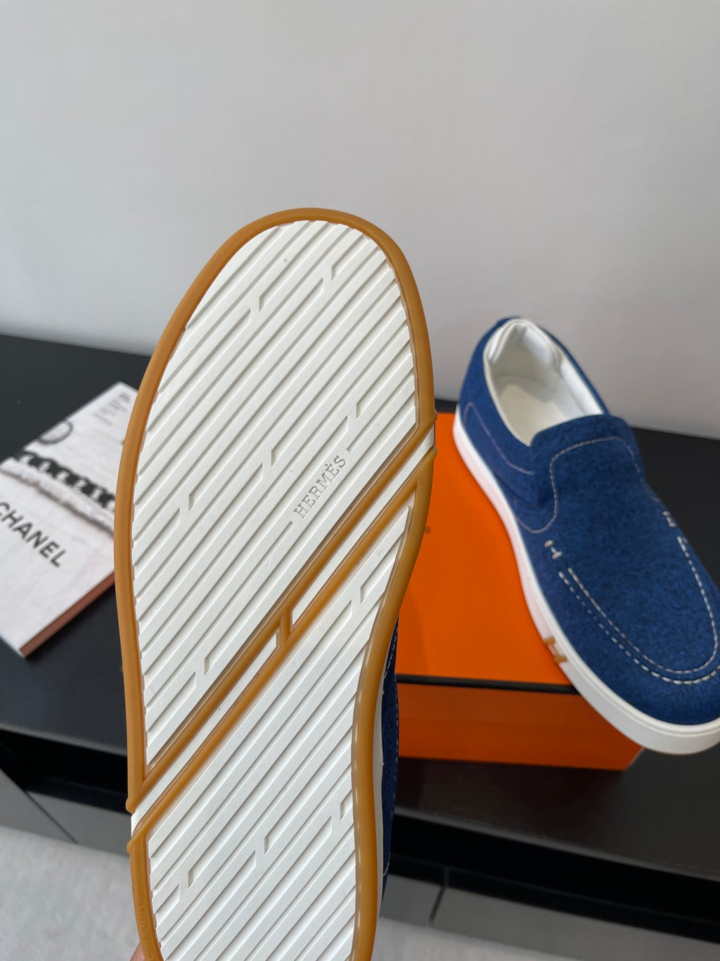 Blue denim slip-on shoe showing textured outsole and white sidewall trim.