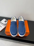 Blue denim slip-on shoes with white rubber sole and contrast topstitching.