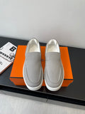 Hermes slip-on sneakers in light gray canvas, rounded toe, stitched side panels