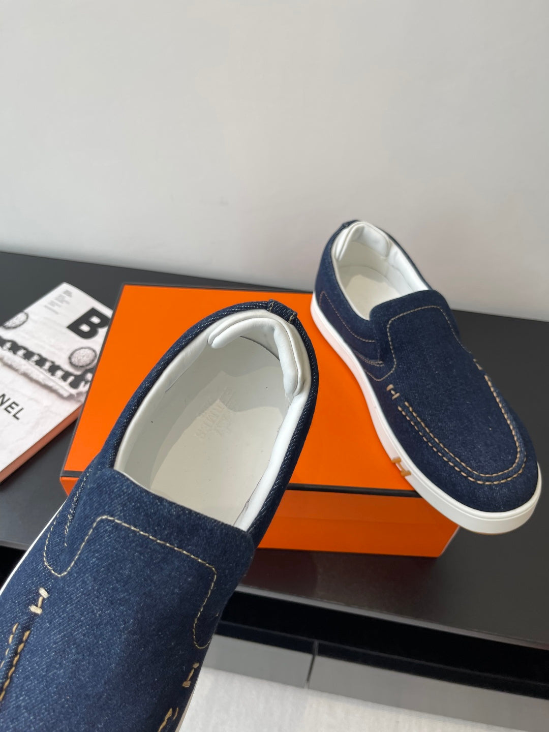 Hermes women's navy denim slip-on sneakers, one showing light-colored interior