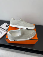 Hermes ladies light gray canvas slip-on sneakers, front profile with white sole, logo strip