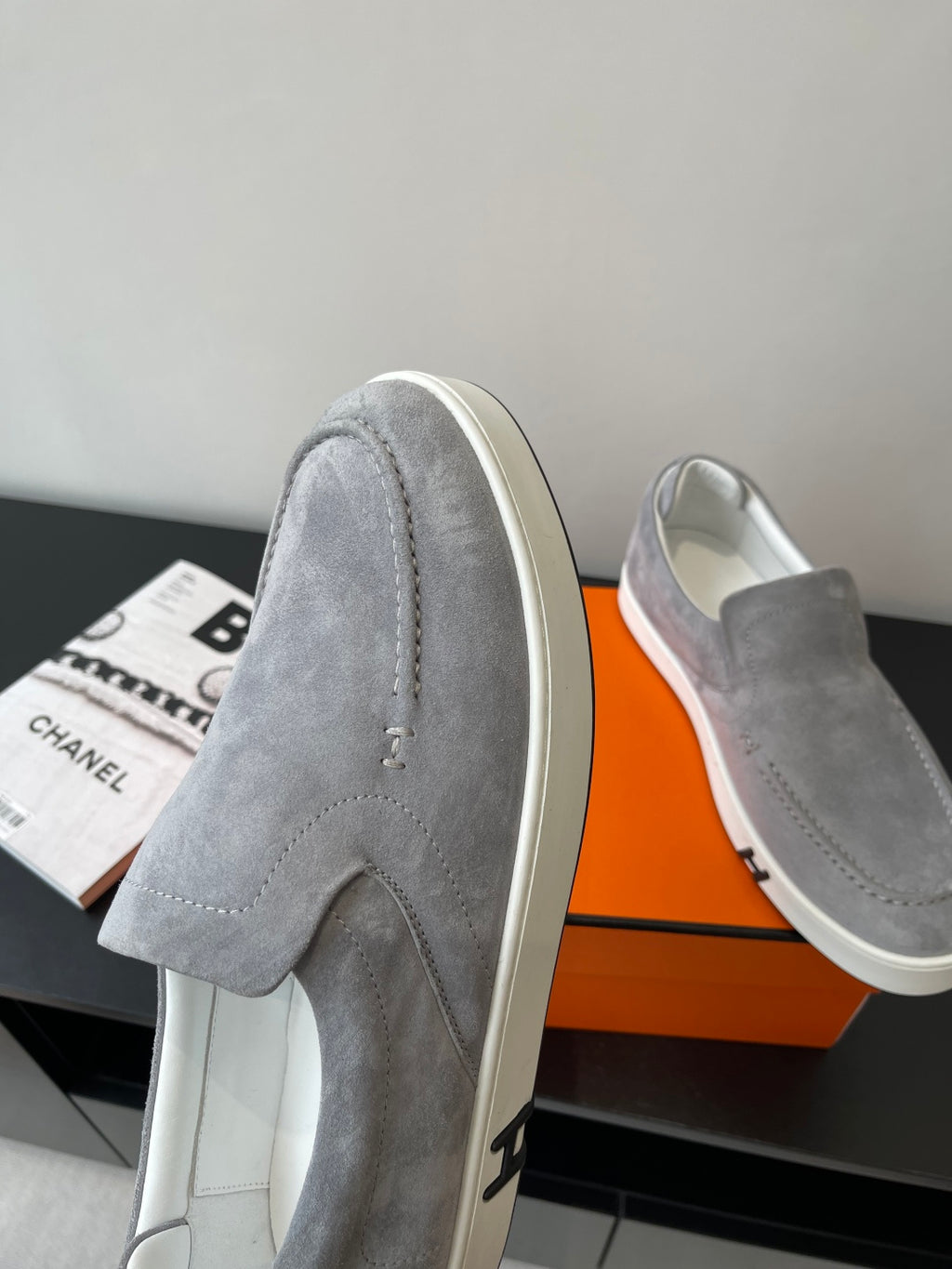 Hermes women’s gray suede slip-on sneakers, top view of one shoe on box