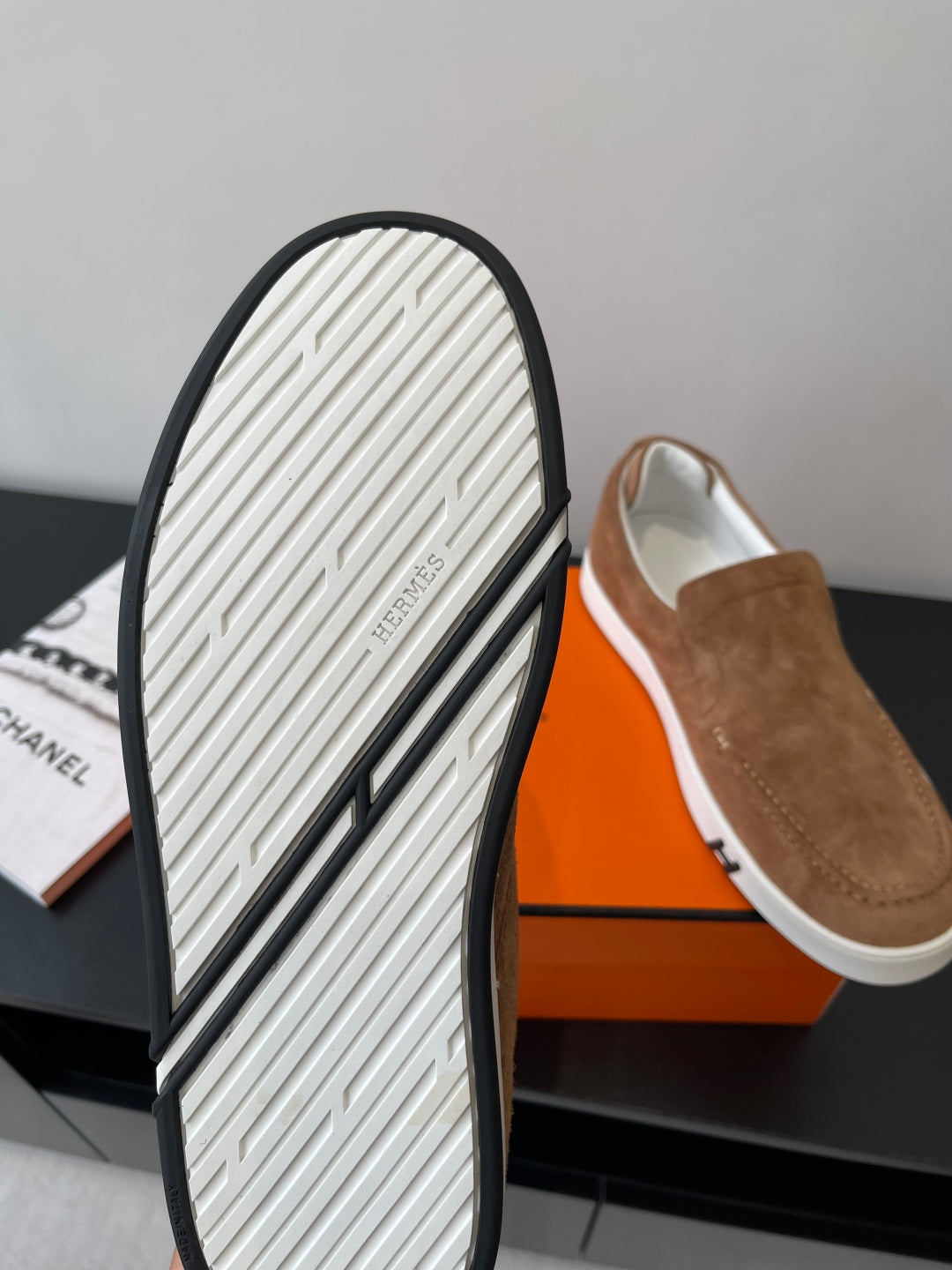 Hermes suede slip-on loafers outsole view, textured white tread and black edge