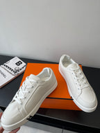 Hermes women’s white sneakers pair on box, lace-up with stitched leather panels