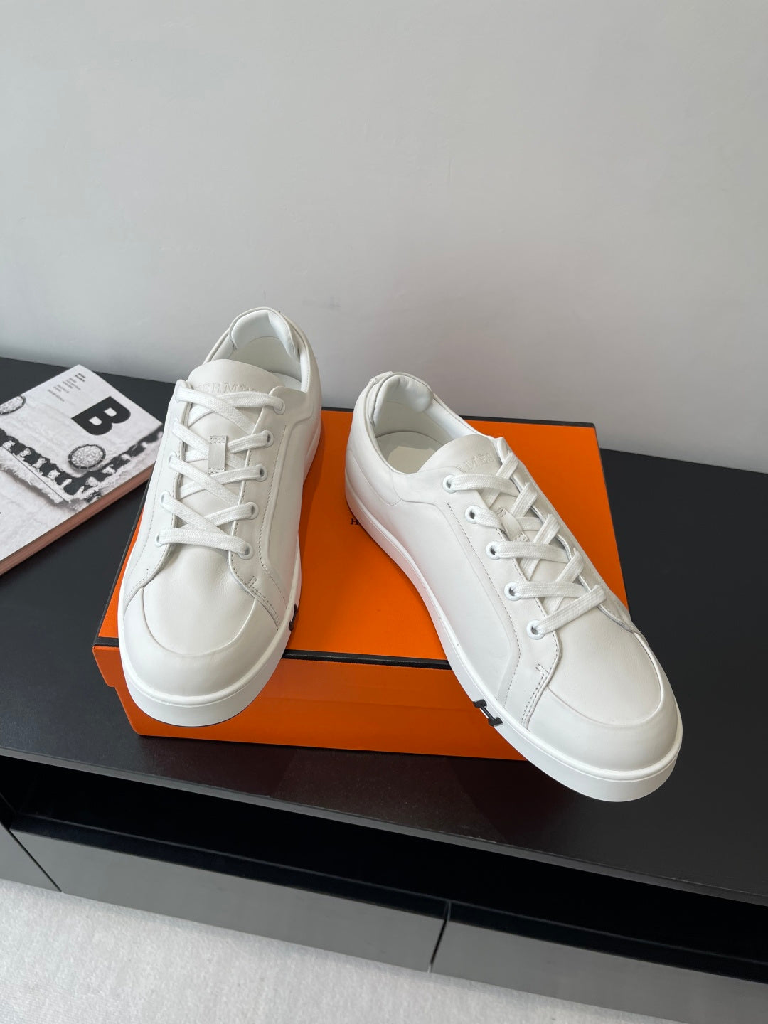 Hermes women’s white lace-up sneakers pair on box, smooth leather and H logo