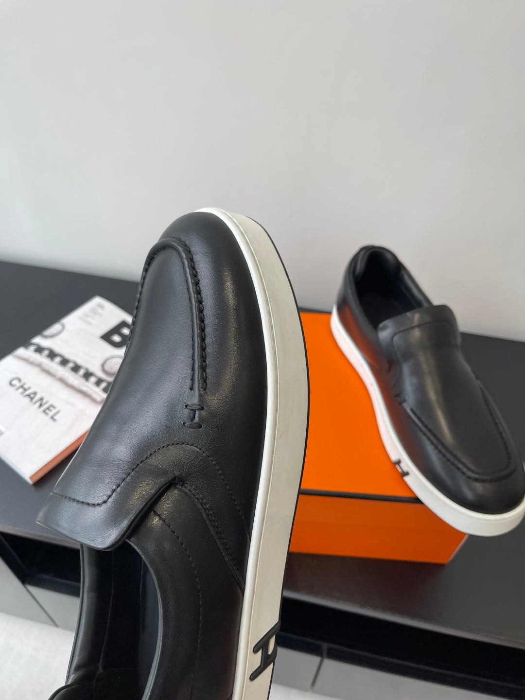 Black leather loafer with white sidewall sole and stitched upper seam