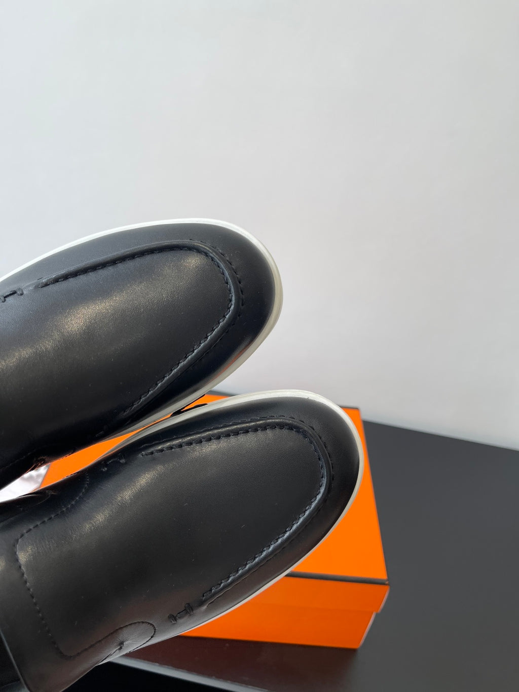 Close-up of black leather loafer toe with stitched seam and smooth finish
