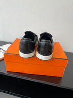 Back view of black leather slip-on loafers with white rubber sole