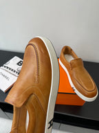 Side view of brown slip-on loafers with white soles and stitched profile.
