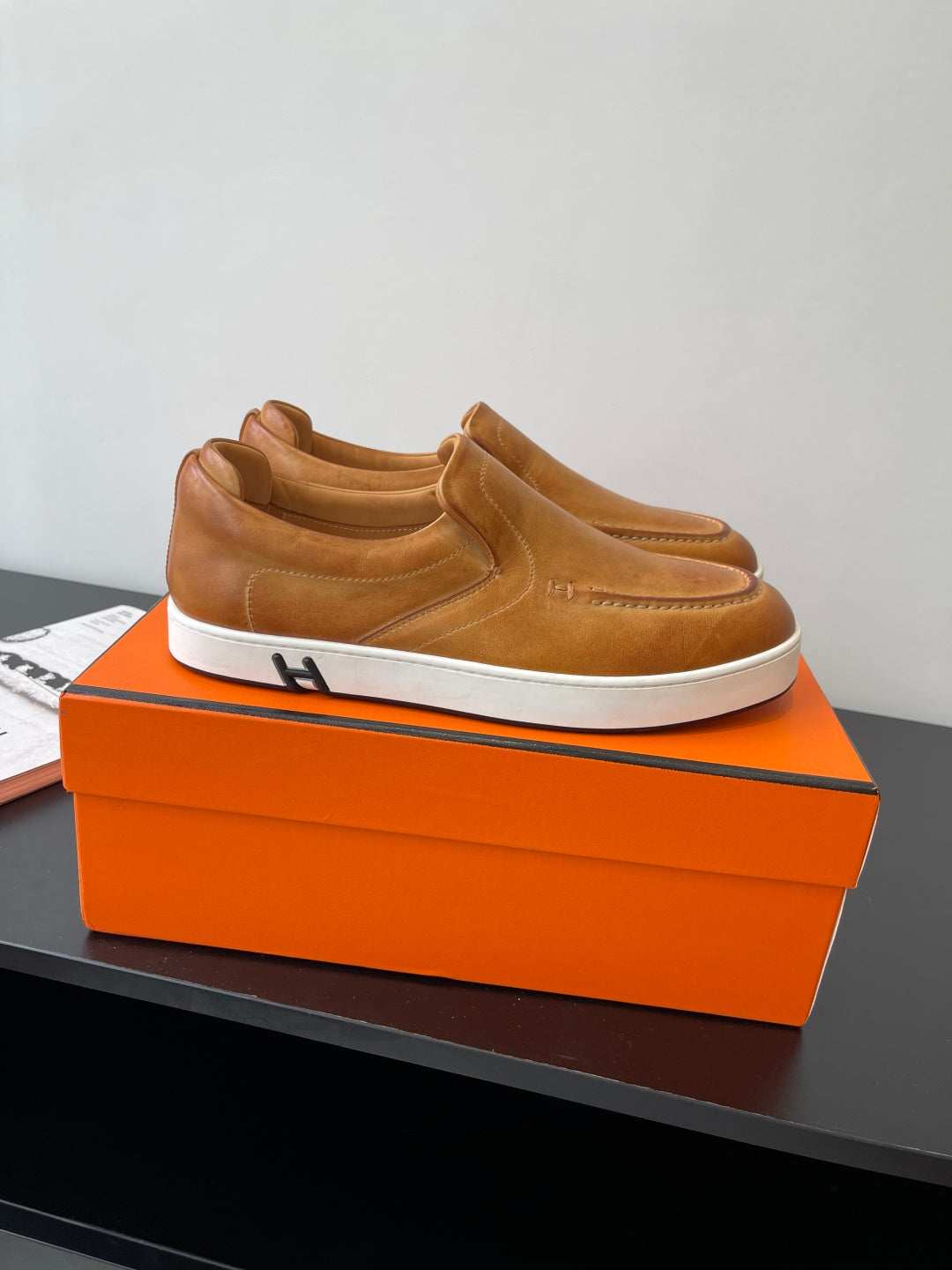 Brown suede or leather slip-on loafers with cushioned collar and white platform sole.