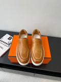 Brown leather slip-on loafers with white rubber sole and stitched moccasin toe.