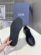 Black leather lace-up sneakers with textured outsole and circular footbed logo