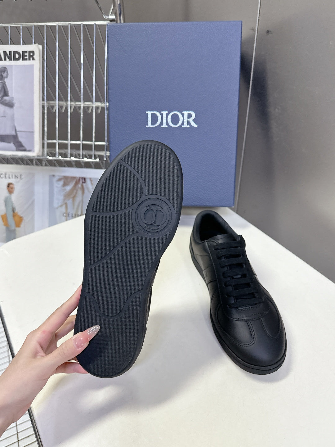 Black leather lace-up sneakers with textured outsole and circular footbed logo