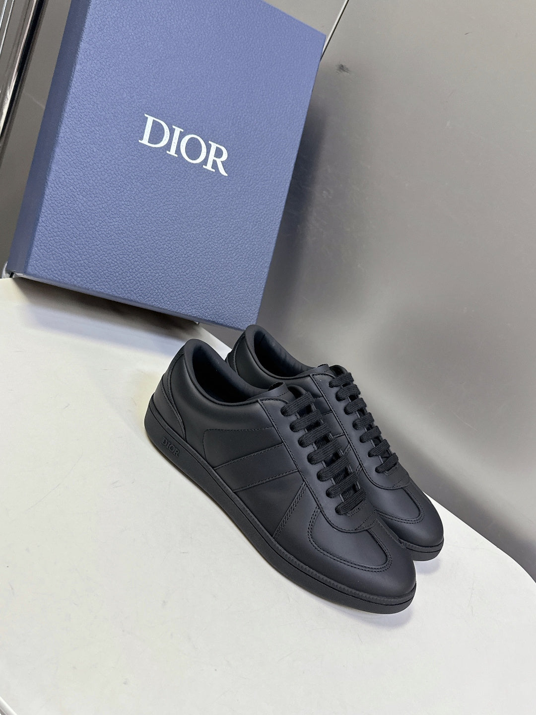 Black lace-up sneakers with stitched panels and low-profile sole