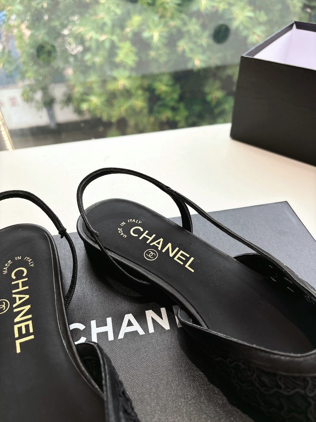Close-up of black Chanel women's slingback shoes, CHANEL logo on insole