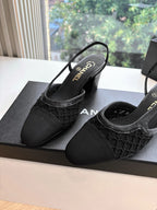 Black Chanel slingback flats with textured toe and logo sole, side view