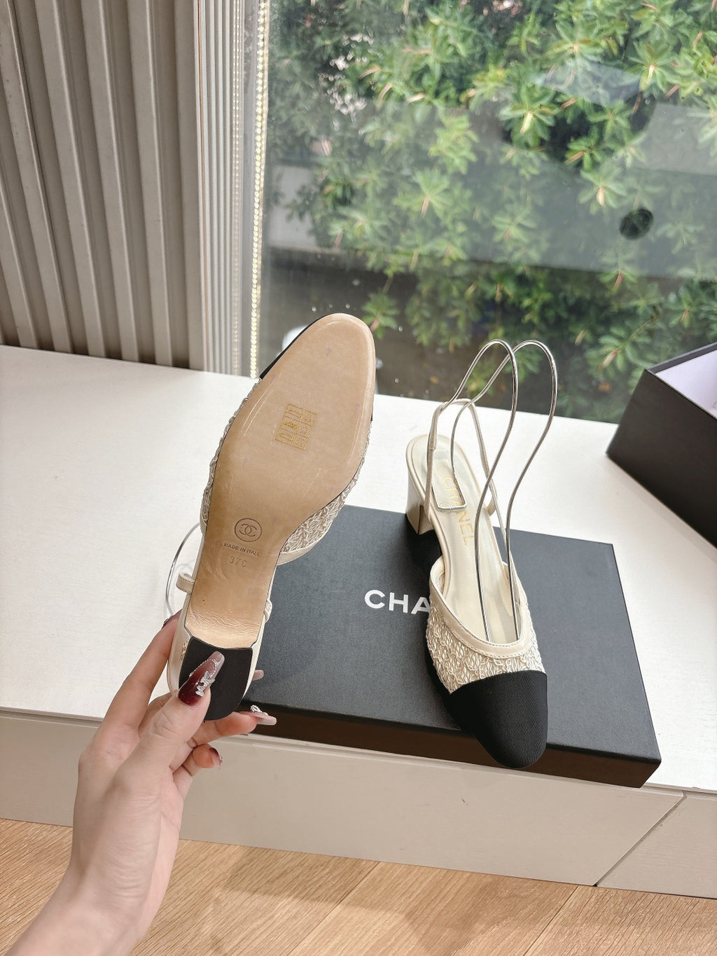Women’s slingback heels with textured beige upper and black toe, seen from sole side