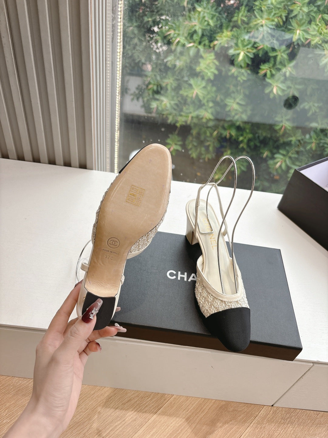 Women’s slingback heels with textured beige upper and black toe, seen from sole side