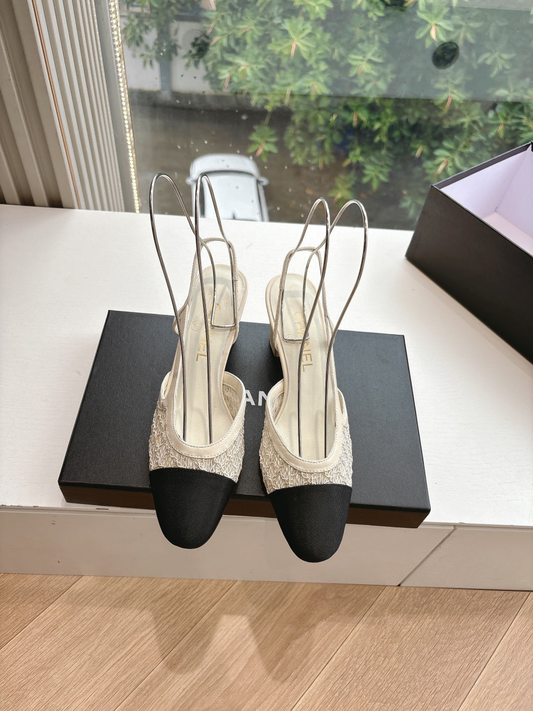Pair of two-tone women’s slingback heels with black toes and textured beige straps