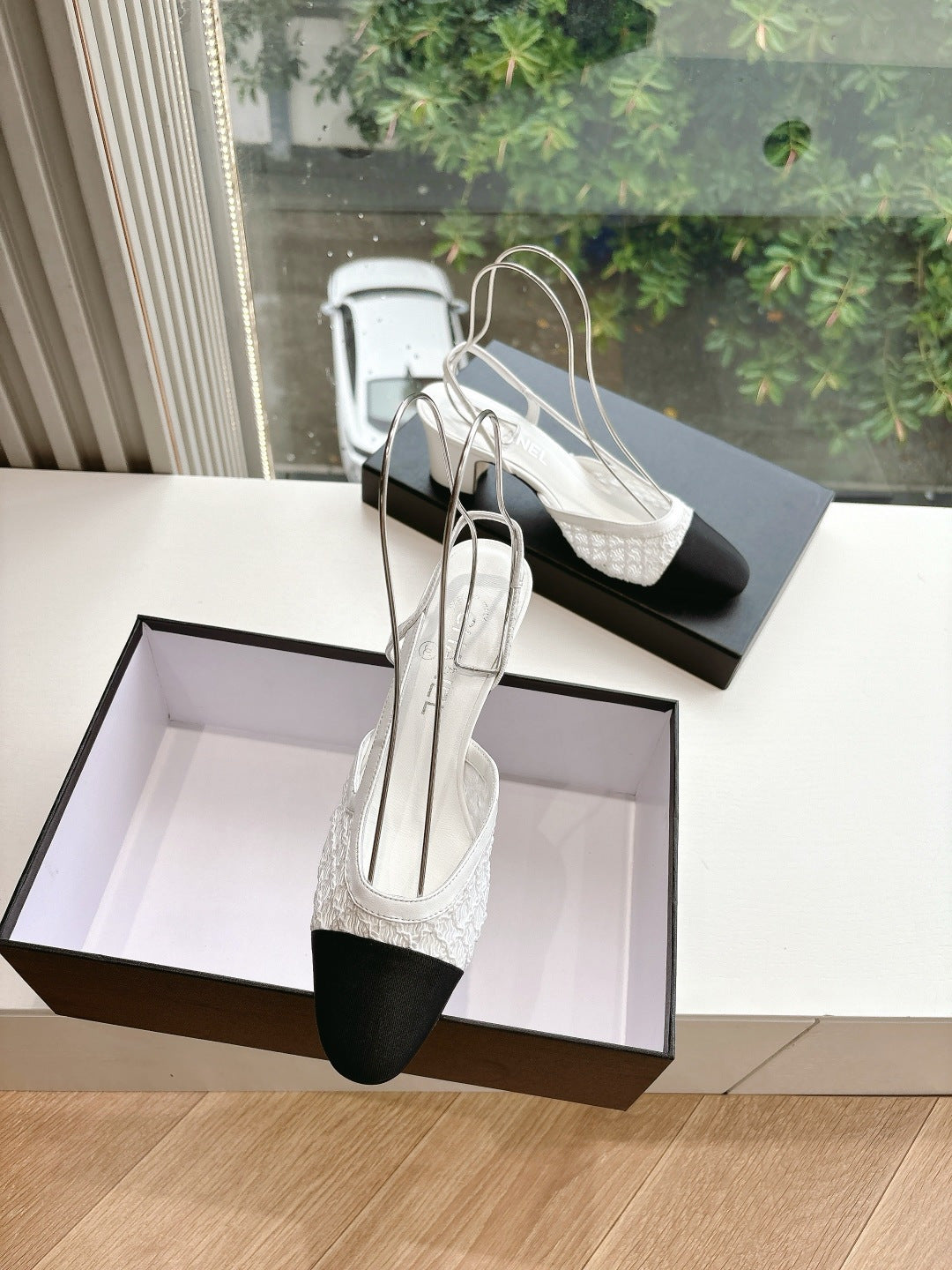 Two-tone slingback heels on display with textured white vamp and dark toe accents