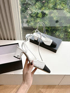 Two-tone women's slingback heel pair with textured white fabric and dark toe cap