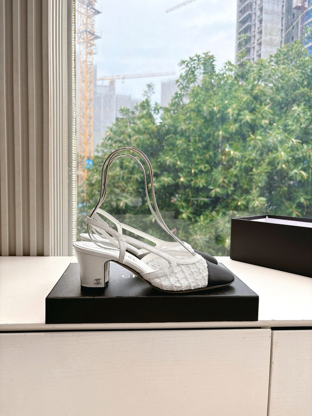 Two-tone slingback heels with textured white upper, dark toe, and stacked mid heel