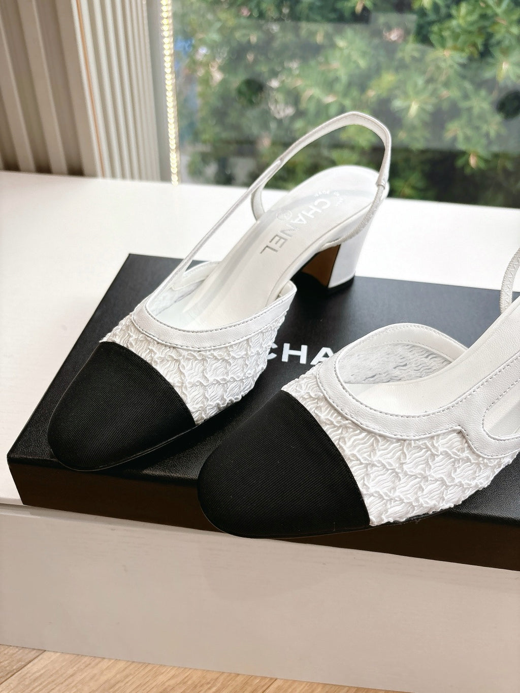 Two-tone women's slingback heels with textured white sides and dark toe blocks
