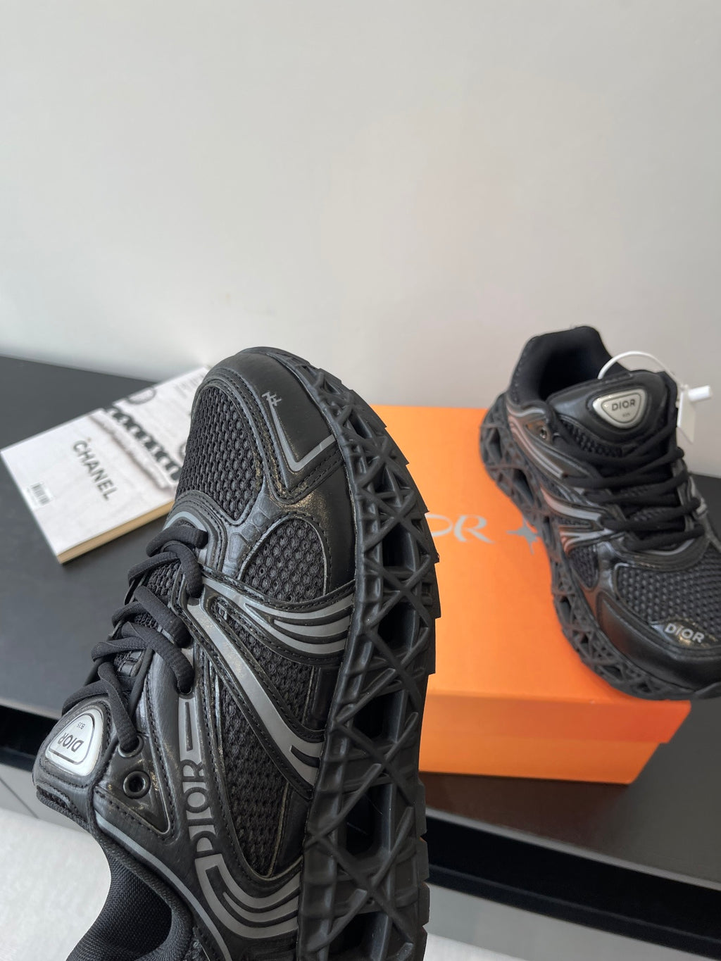 Dior ladies sneaker side, black mesh with diagonal stripes and Dior badge