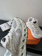 White sneaker side view with textured sole tread and mesh overlays
