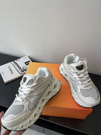 Pair of white chunky lace-up sneakers with mesh panels and logo accents