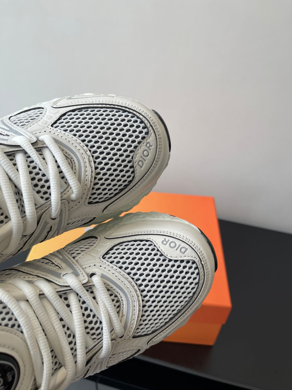 Close-up of white mesh sneaker upper with Dior logo on side panels