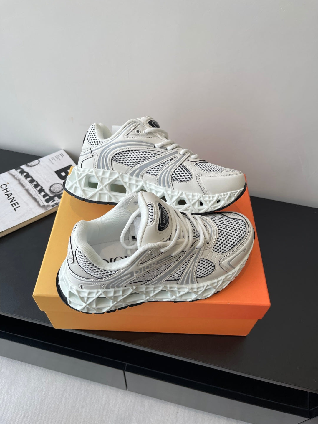 White pair of chunky lace-up sneakers with mesh upper and logo accents