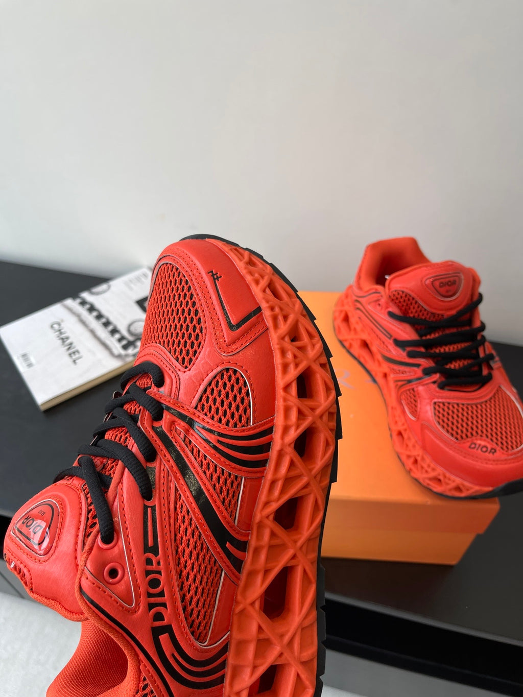 Red Dior sneakers with black laces and sculpted sole, side view