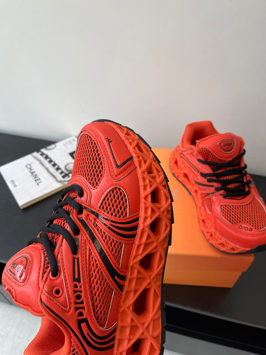 Red Dior sneakers with black laces and sculpted sole, side view