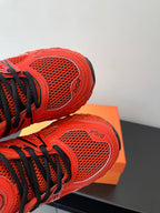Red Dior ladies sneakers close-up of perforated mesh toe and side logo