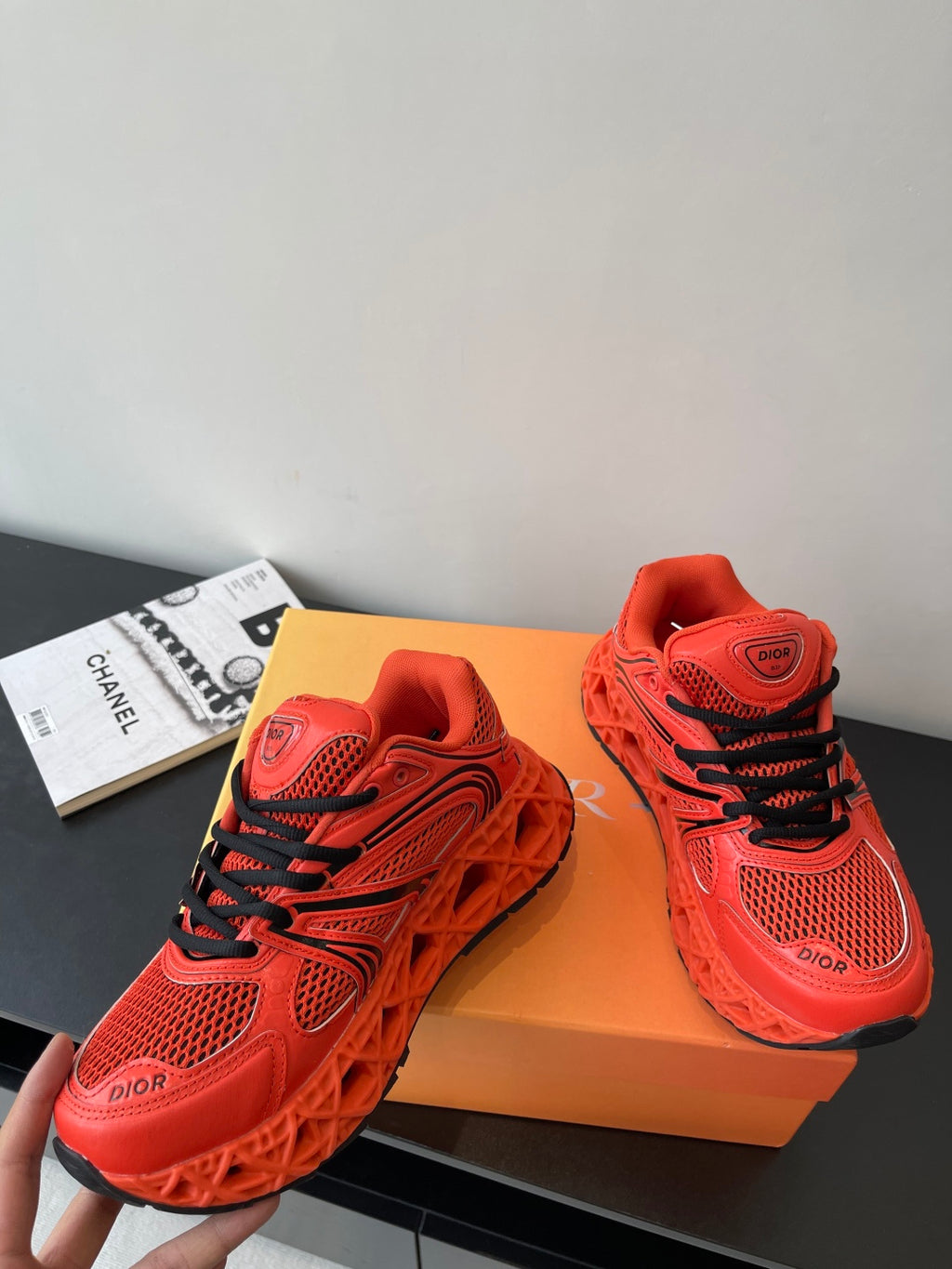 Red Dior ladies sneakers, angled view, black lace stripes and mesh panels