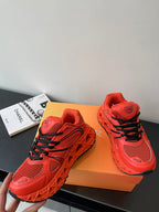 Red Dior ladies sneakers, angled view, black lace stripes and mesh panels
