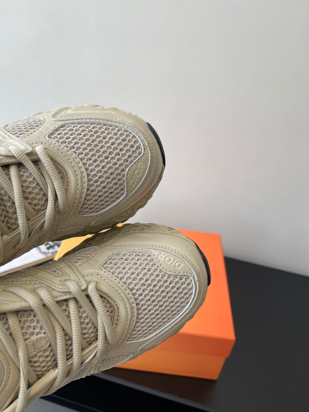 Cream sneaker side view with textured mesh upper and thick lace-up panels