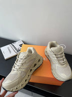 Cream lace-up sneakers, left and right pair with textured sole and laces