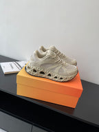 Cream lace-up sneaker on orange box, mesh and panel details visible