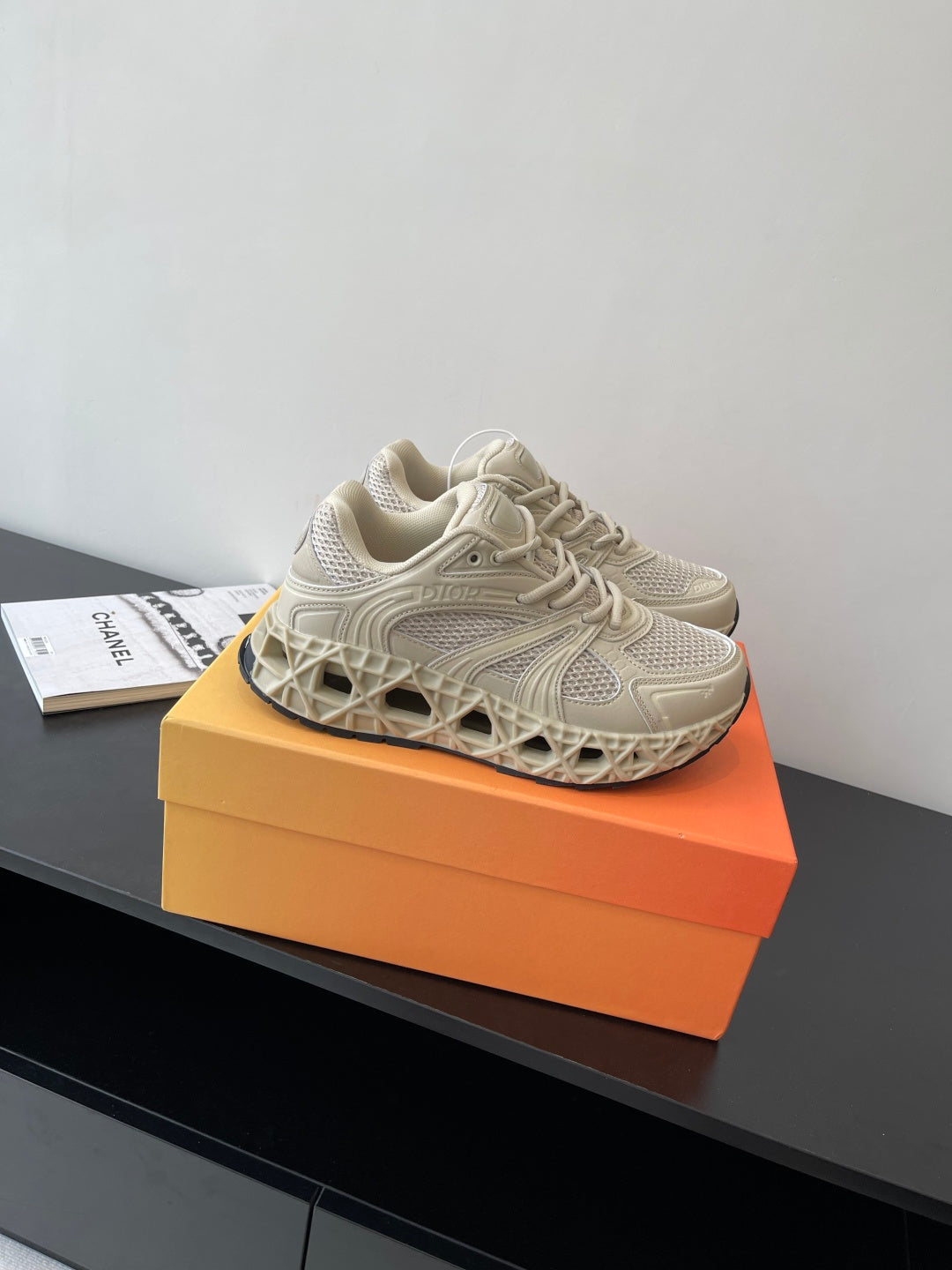 Cream lace-up sneaker on orange box, mesh and panel details visible