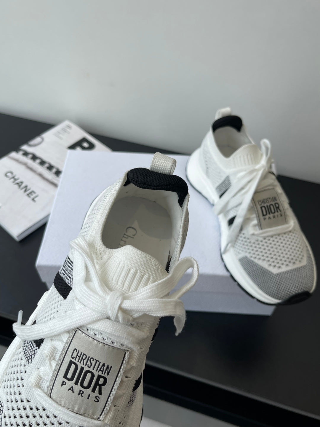 White mesh sneaker with black side stripe, white laces, Dior Paris logo on tongue