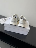 White lace-up sneakers with black accent stripes and Dior logo heel tabs
