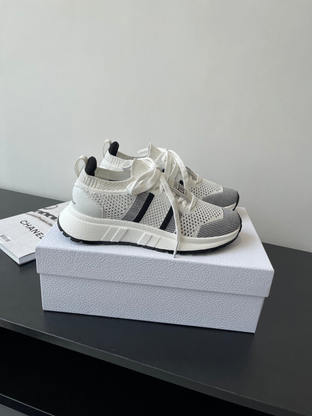 White mesh sneaker with black side stripes and white knit collar, lace-up front